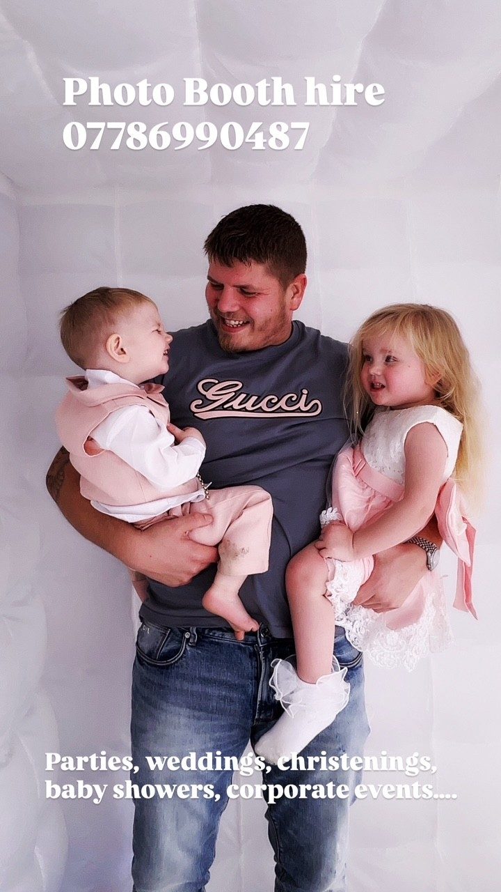 Photo booth hire for all occasions A man in casual clothing holds two toddlers in a photo booth setting.