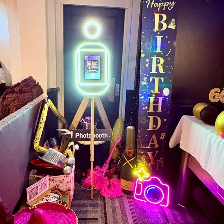 Photo booth hire for any occasion A couple posing together in front of a vintage pod photobooth with lights.